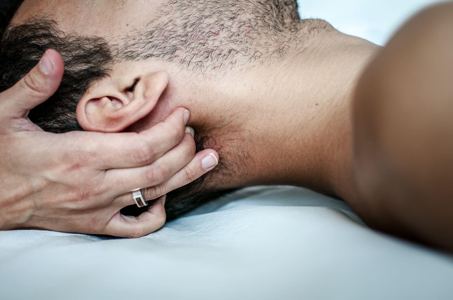 physiotherapist massages young patient to cure a cervical pain physiotherapist massages young patient to cure a cervical pain